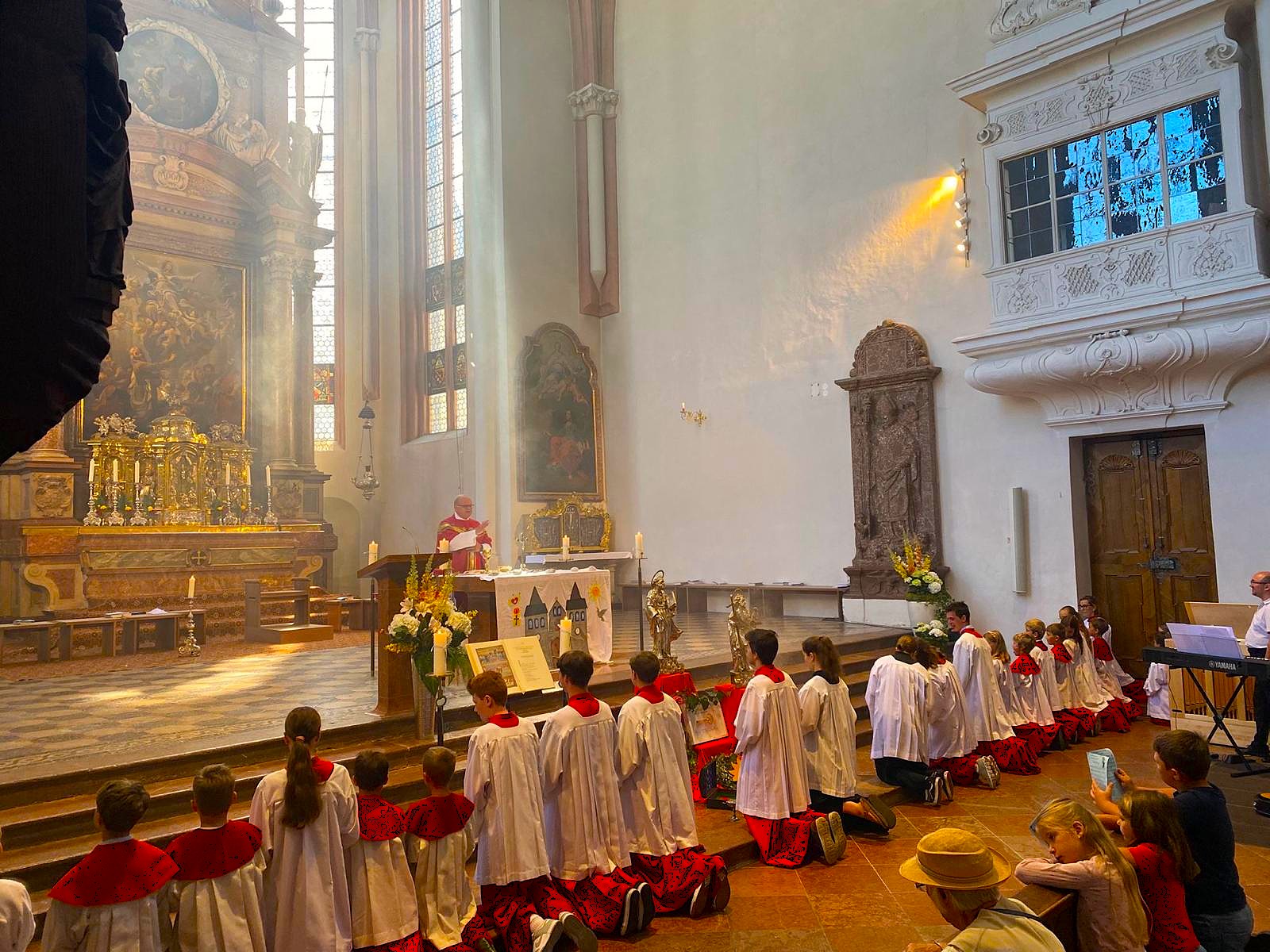 Ministranten knien vor dem Altar